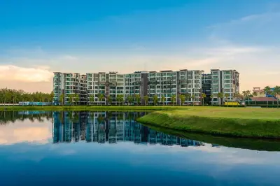 a large apartment building next to a body of water at Wyndham Phuket Airport in Nai Yang Beach