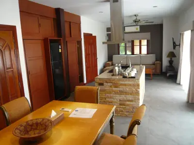 a living room with a dining table and a kitchen at The Pace Phuket Boutique Resort in Rawai Beach