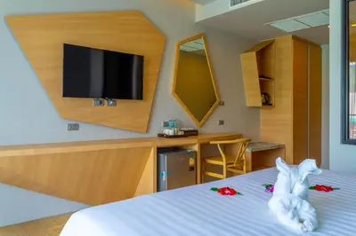 a hotel room with a bed with a tv on the wall at Golden Paradise Hotel - SHA PLUS in Karon Beach