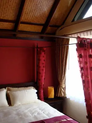 a bedroom with a bed with red walls and a window at Sunset Apartment Phuket in Patong Beach