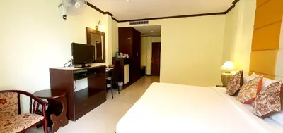 a hotel room with a bed and a television at The Mareeya Place in Kamala Beach