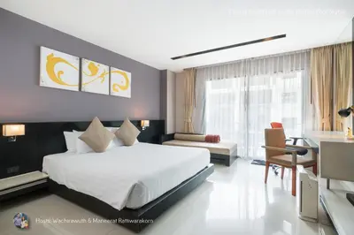 a bedroom with a large white bed and a desk at ✪✪✪✪✪ Patong Beachfront Studio Rooftop Pool Skybar in Patong Beach