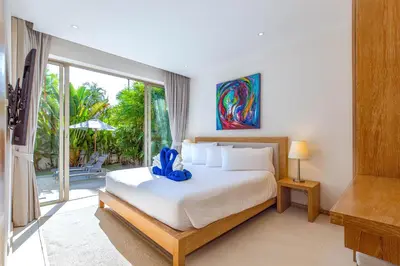 a bedroom with a bed with a blue ribbon on it at Sunny 3BR Villa with Private Pool at Bangtao Beach in Bang Tao Beach