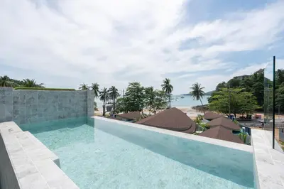 a swimming pool with a view of the beach at Panwaburi Beachfront Resort - SHA Extra Plus in Panwa Beach