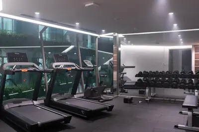 a gym with several treadmills and machines in a room at Panwaburi Beachfront Resort - SHA Extra Plus in Panwa Beach