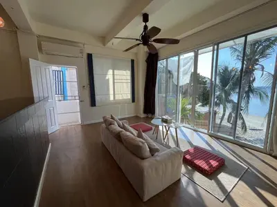 a living room with a couch and a ceiling fan at AT SEA Patong in Patong Beach