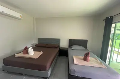 two beds in a room with two beds sidx sidx sidx sidx at Davy Cottage Phuket in Thalang