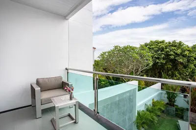 a balcony with a chair and a table at Lovely pool villa 2 bedrooms in rawai with seaview in Ban Saiyuan (1)