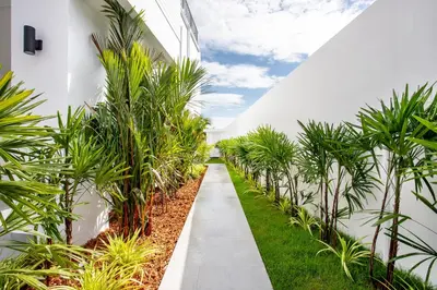 a walkway through a greenhouse with palm trees at Lovely pool villa 2 bedrooms in rawai with seaview in Ban Saiyuan (1)