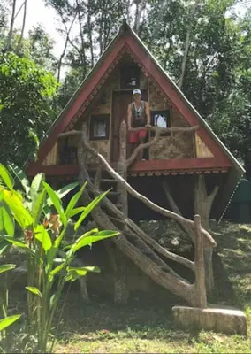 a woman is sitting in a tree house at Treehouse Holidays-Little house in Ko Yao Noi