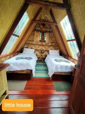 a attic bedroom with two beds in a house at Treehouse Holidays-Little house in Ko Yao Noi