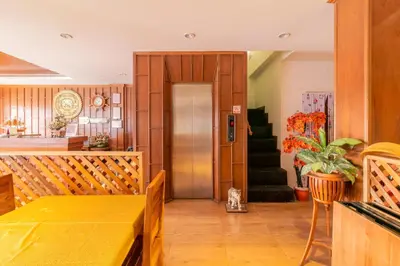 a dining room with a table and a refrigerator at Lotus Hotel Patong in Patong Beach