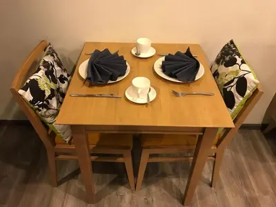 a wooden table with plates and utensils on it at The deck patong 5 Star Apartment \u5df4\u4e1cThe Deck\u65e0\u8fb9\u9645\u6d77\u666f\u6cf3\u6c60\u9152\u5e97 in Patong Beach
