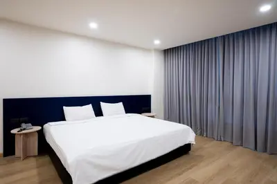 a bedroom with a large white bed and a window at CA Hotel and Residence Phuket - SHA Extra Plus in Phuket Town