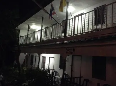 a building with a balcony with a flag on it at Coco's Guest House in Phi Phi Don