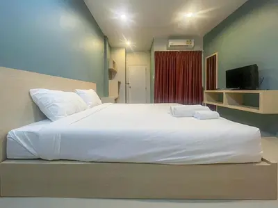 a large white bed in a room with a television at Hop On Phuket in Ban Bo Han