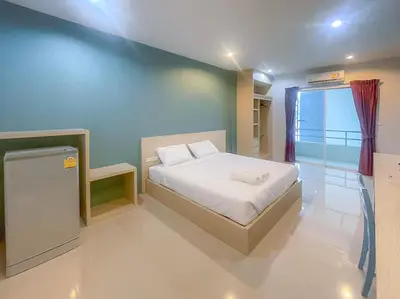 a small bedroom with a bed and a window at Hop On Phuket in Ban Bo Han