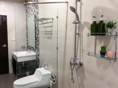 a bathroom with a shower and a toilet and a sink at Koh Sirey Beachfront Pool Villa - 2 Bedrooms House in Phuket Town