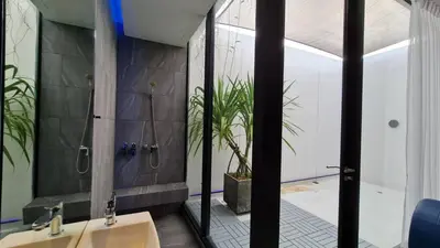 a bathroom with two sinks and a plant in the shower at INNLUXPHUKET in Ban Laem Hin