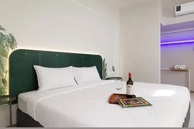a bed with a bottle of wine and a glass at INNLUXPHUKET in Ban Laem Hin