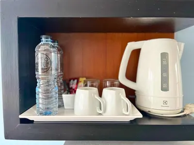 a shelf with two cups and a bottle of water at Z&Z House in Rawai Beach