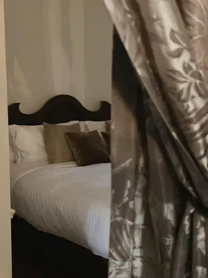 a bed with a black headboard and pillows at Hotel Verdigris in Phuket Town
