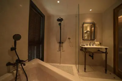 a bathroom with a bath tub and a sink at Hotel Verdigris in Phuket Town