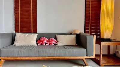 a gray couch with two pillows on it in a room at Aonang Phu Dahla Private Pool & Sea View - SHA Plus in Ao Nang Beach