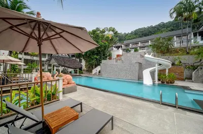 an outdoor swimming pool with a water slide at Andamantra Resort and Villa Phuket in Patong Beach