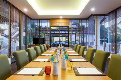 a long wooden table with chairs in a conference room at Andamantra Resort and Villa Phuket in Patong Beach