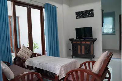 a living room with a table and chairs and a television at Purepamvillage in Kata Beach