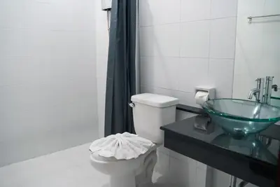 a bathroom with a toilet and a glass sink at Purepamvillage in Kata Beach