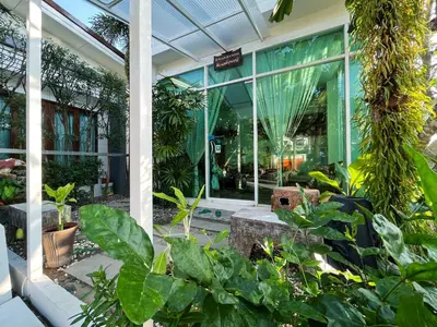 a greenhouse with plants in front of a building at Purepamvillage in Kata Beach