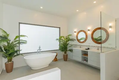 a bathroom with a large window and a tub and two sinks at villa Akala in Ban Saiyuan (1)