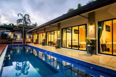 a swimming pool in front of a house at De palm poolvilla by KC in Ban Chin Tham Mai