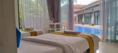 two beds in a room with a swimming pool at De palm poolvilla by KC in Ban Chin Tham Mai
