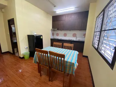 a small kitchen with a table and a refrigerator at Nanai 2 Residence Patong Phuket in Patong Beach