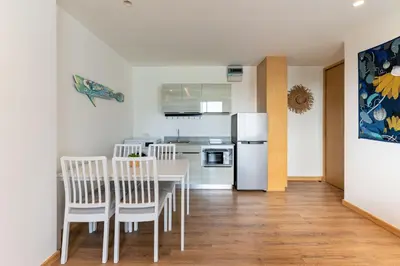 a kitchen and dining room with a table and chairs at Aristo 2 Phuket by RESAVA in Surin Beach