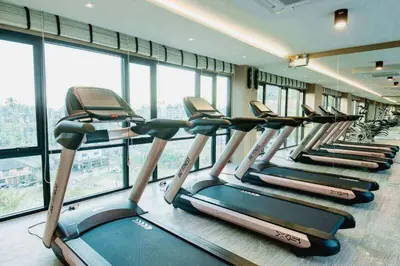 a row of cardio machines in a gym with windows at Aristo 2 Phuket by RESAVA in Surin Beach