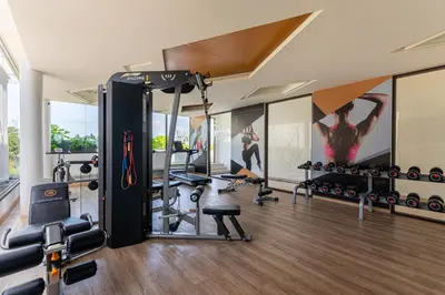 a gym with exercise equipment and a wall mural at Aristo 2 Phuket by RESAVA in Surin Beach