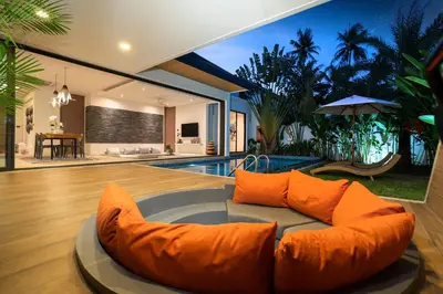 a living room with a couch in front of a pool at Sunny Day Dream Villa - Nai Yang Beach in Thalang