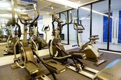 a gym with rows of treadmills and elliptical machines at The Beach Heights Resort SHA Plus in Kata Beach