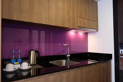 a kitchen with a sink and a purple wall at The Beach Heights Resort SHA Plus in Kata Beach