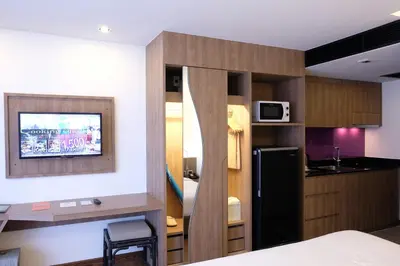 a room with a kitchen with a refrigerator and a microwave at The Beach Heights Resort SHA Plus in Kata Beach