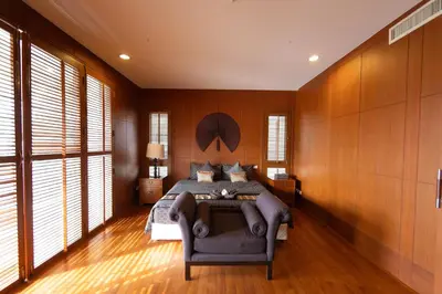 a bedroom with wooden walls and a bed and a couch at Laguna Links Golf View Villa- Bangtao Beach in Phuket Town