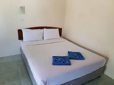 a white bed with two blue shoes on it at Dalum Beachhouse in Phi Phi Don
