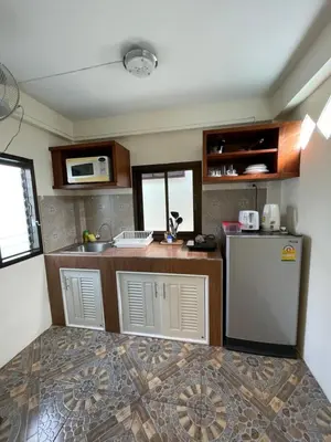 a kitchen with a counter and a refrigerator at Ron Bungalow in Bang Tao Beach