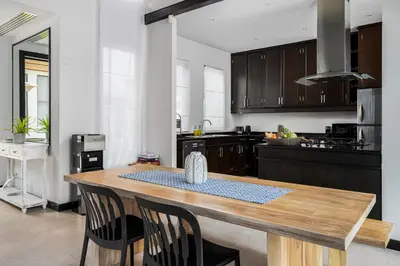 a kitchen with a wooden table and some chairs at Tropical 3BR Holiday Villa with Pool, BBQ, and Shaded Patio within Walking Distance to Bang Tao Beach in Bang Tao Beach