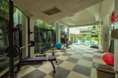 a fitness room with a gym with a swimming pool at Karon View Apartments in Karon Beach