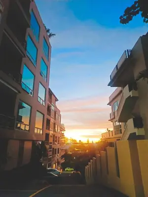 a view of a building with the sunset in the background at Karon View Apartments in Karon Beach